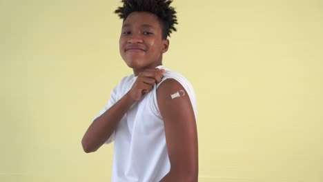 African-American-teenager-showing-COVID-19-vaccine-bandage-merrily