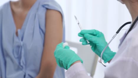 Young-woman-visits-skillful-doctor-at-hospital-for-vaccination
