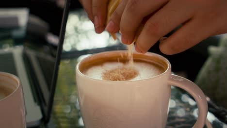 Close-up-with-selective-focus-pouring-sugar-to-a-latte