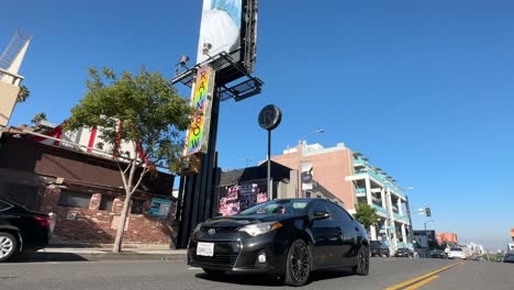 Famous-Rainbow-Bar-and-Grill-on-Sunset-Boulevard,-low-angle-shot-with-cars-passing-by