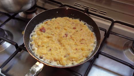 Close-up-of-a-pan-cooking-and-sizzling-traditional-Spanish-tortilla-food