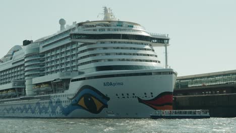Aida-Prima-Cruise-Ship-docked-in-Hamburg-next-to-a-small-Hafen-barkasse