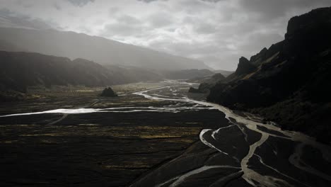 Espectacular-Paisaje-Aéreo-Valle-De-Thor,-Río-Glacial-Que-Fluye-A-Través-De-La-Montaña-Volcánica-Negra,-Parque-Nacional-De-Thorsmörk-Islandia