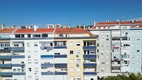 Stadtbild-Von-Lissabon,-Portugal,-Enthüllt-Durch-Eine-Drohnenaufnahme,-Die-Von-Einem-Vordergebäude-Aus-Beginnt-Und-Langsam-Ansteigt,-Um-Den-Blick-Auf-Die-Stadt-Zu-Zeigen