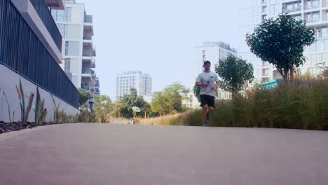 young-asian-man-male-runner-jogger-running-jogging-outdoors-holding-phone-tiktok