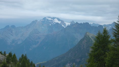 Vista-Panorámica-Inclinada-De-Exuberantes-Montañas-Cubiertas-De-Bosques-Y-Paisajes-Nublados-En-Alpe-Prabello,-Italia