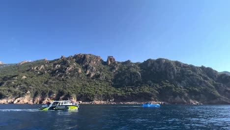Memorable-tour-boat-at-Calanques-de-Piana-volcanic-eroded-rock-formations-in-Corsica-island-in-summer-season,-France