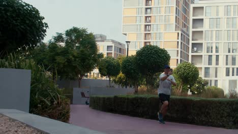young-asian-man-male-runner-jogger-running-jogging-outdoors-holding-smart-phone