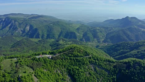 Aerial-panoramic-shot-of-green-mountain-range-of-Rhodope-Mountains-and-holy-Krastova-Gora