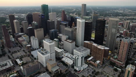 Aerial-tracking-shot-of-the-downtown-Houston-skyline,-colorful-dusk-in-TX,-USA