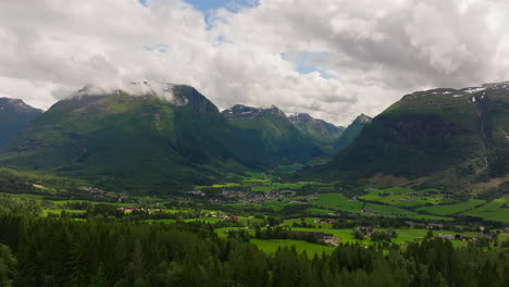 Un-Dron-Se-Eleva-Sobre-El-Bosque-De-La-Ladera-Para-Revelar-El-Amplio-Valle-De-Byrkjelo,-Noruega