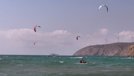 Kite-surfer-stands-up-and-rides-in-rough-ocean-in-Kefalonia,-Greece,-telephoto