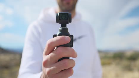 Vlogger-showing-modern-DJI-Osmo-Pocket-3-stabilized-intelligent-tracking-mobile-gimbal-camera-for-creative-videography