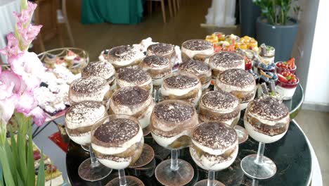 Mit-Schokolade-Bestäubtes-Tiramisu-Dessert,-Serviert-In-Eleganten-Gläsern