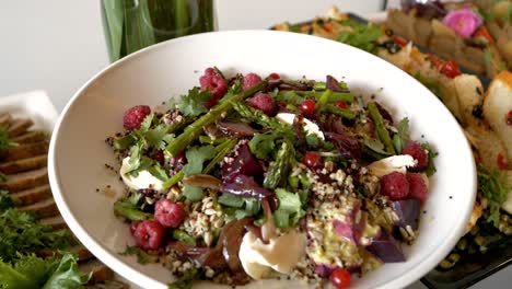 Platter-with-a-salad-consisting-of-raspberries,-asparagus,-red-currants,-sunflower-seeds,-and-pieces-of-beetroot