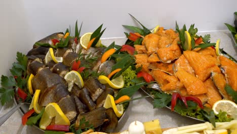 Platters-with-smoked-fish,-adorned-with-slices-of-lemon-and-orange