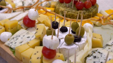 Cheese-board,-pieces-adorned-with-cherry-tomatoes,-olives,-and-mozzarella-balls