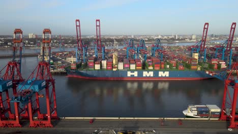 Aerial-footage-of-a-shipping-yard-and-cargo-ships-being-loaded-with-cranes