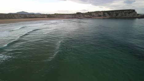 Grupo-De-Surfistas-Esperando-Las-Olas-Del-Océano-En-La-Costa-Cantábrica-De-España
