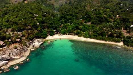 Slowly-pulling-in-on-an-aerial-drone-shot-of-the-beachfront-of-Haad-Tian-beach-located-in-Koh-Tao-island-in-Surat-Thani-province,-Thailand