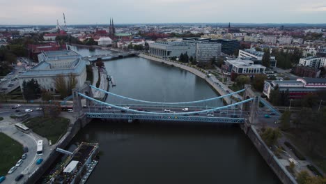 Rushed-traffic-on-the-Grunwaldzki-Bridge-in-Wrocław,-Poland,-from-a-drone-perspective