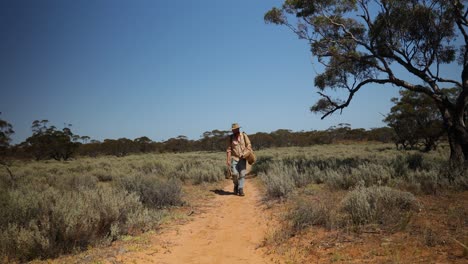 An-old-vintage-looking-swag-man-walks-through-the-Australian-outback