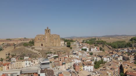 An-enchanting-circular-drone-shot-of-the-Catholic-Church-Santa-Maria-de-Balaguer-in-Lleida,-Spain,-basking-in-the-golden-afternoon-sun