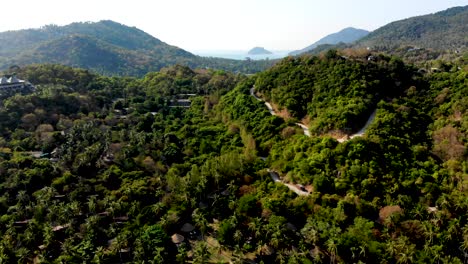 A-pull-in-aerial-drone-shot-of-the-mountain-and-hilly-highways-of-Shark-bay-in-Koh-Tao-island-that-is-slowly-revealing-the-rest-of-the-islands-on-the-other-side,-in-Chumpon-province-in-Thailand