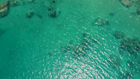 A-slow-reveal-aerial-drone-shot-showing-some-tourists-who-are-swimming-and-sunbathing-on-the-sandy-white-sands-and-crystal-clear-blue-waters-of-Ao-Hin-Wong-beach-in-Koh-Tao-island-in-Thailand