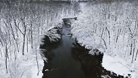 As-the-drone-gracefully-ascends-above-the-tranquil-Midwest-countryside,-a-pristine-winter-wonderland-unfolds