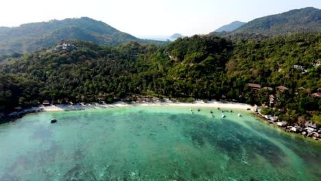 An-aerial-drone-shot-pull-in-of-Shark-Bay,-a-secluded-beach-resort-famous-for-snorkeling-in-Kho-Tao-island,-Chumpon-province-in-Thailand