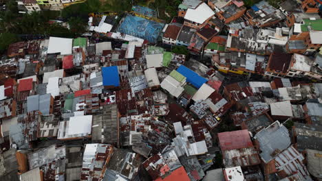 High-angle-drone-shot-over-colorful-slum-houses-in-San-Javier,-comuna-13,-Medellin,-Colombia