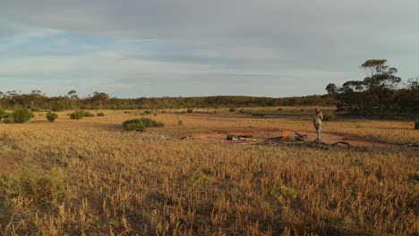 Wide-shot-of-a-beautiful-outback-landscape-with-an-authentic-bushman-swag-camping-on-a-grassy-plain