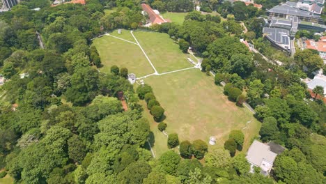 Aerial-perspective-over-Singapore's-Fort-Canning-Park,-revealing-a-lush-oasis-nestled-in-the-heart-of-the-city
