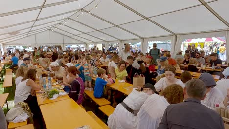 South-Tyrolean-Medieval-Games,-People-sit-in-a-food-tent
