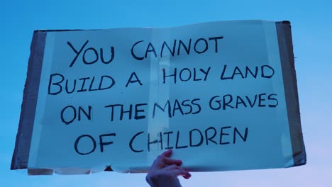 Placard-at-National-March-for-Palestine-and-Gaza-Protest-in-London,-UK---"You-cannot-Build-a-Holy-Land-on-the-Mass-Graves-of-Children