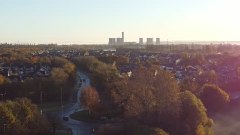 Early-morning-sunrise-power-station-skyline-aerial-view-descending-to-Autumn-British-townhouse-neighbourhood