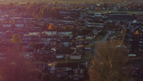 Luftaufnahme-Einer-Stadthaussiedlung-Im-Nordwesten-Des-Vereinigten-Königreichs-Mit-Frühmorgendlichem-Sonnenaufgang,-Licht-Leckt-über-Herbstlich-Gefärbte-Bäume-Und-Dächer