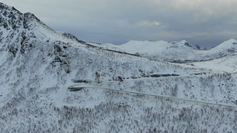 Drone-view-in-Tromso-area-in-winter-flying-over-white-mountains-in-Norway-between-valleys