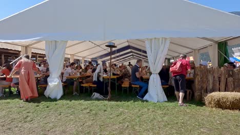 South-Tyrolean-Medieval-Games,-People-sit-in-a-food-tent-and-consume-some-food