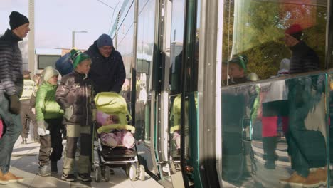 Young-and-old-people-board-new-commuter-transit-train-in-Helsinki,-FIN