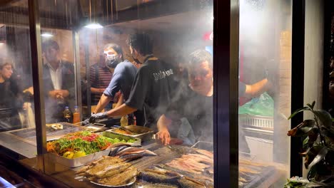 Turkish-street-food-delicious-fish-wrap-sea-food-Istanbul-cuisine-gourmet-cooking-barbecue-BBQ-sandwich-fire-smoke-fry-salad-bar-grill-cooking-farmer-market-galata-port-vegetable-spices-local-Turkey