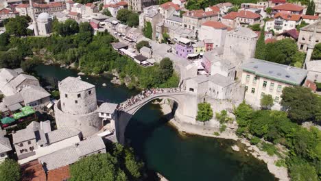 Crowded-Stari-Most-arch-bridge-over-Neretva-river-in-Mostar's-heart,-Bosnia
