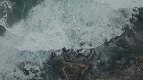 Static-aerial-shot-of-sea-waves-moving-toward-to-the-coastline---Top-down-view