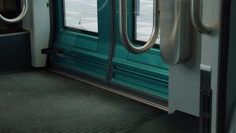 Shiny-teal-doors-close-on-modern-urban-public-transit-commuter-train