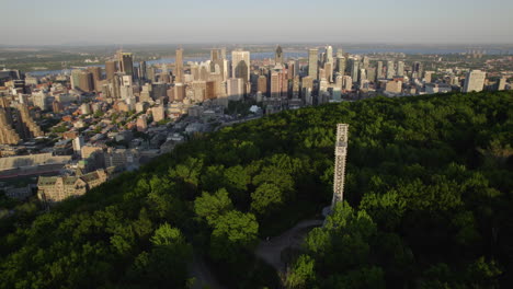 Aerial-view-around-the-cross-on-top-of-Mount-Royal-with-Montreal-skyline-background