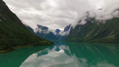 Lovatnet-Loen-lake-with-mountain-fog-around-dramatic-mountains,-Norway