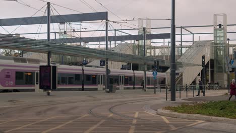 Modern-commuter-transit-train-departs-station-in-Helsinki,-Finland