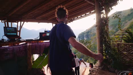 DJ-performs-grateful-gestures-touching-his-heart-with-his-hands-in-Guatemala-performing-on-a-stage-overlooking-lake-atitlan-and-its-volcanos