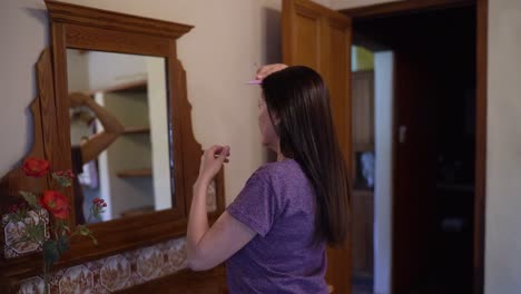 Woman-Combing-Her-Long-Hair-In-Front-Of-Vanity-Mirror
